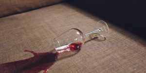 Copa de vino derramada sobre una superficie, simbolizando el impacto de las nuevas restricciones de publicidad sobre el consumo de alcohol en España.
